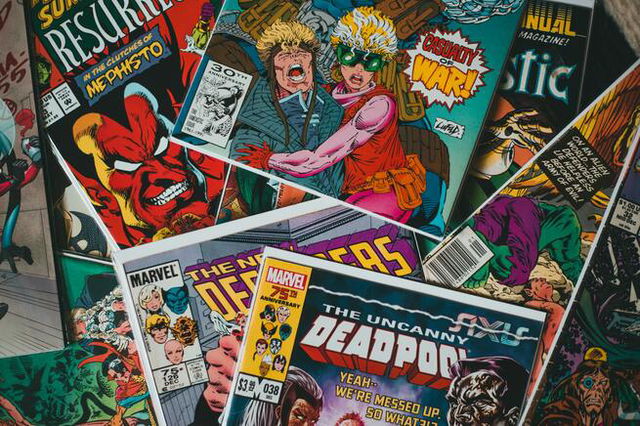 A pile of comics, none completely in image. Colourful and bright. The words Marvel and Deadpool visible