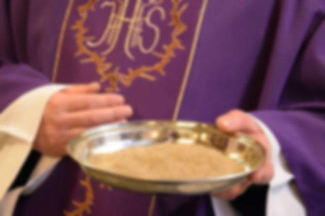 Sacerdote sostiene el plato de la ceniza durante el Miércoles de Ceniza