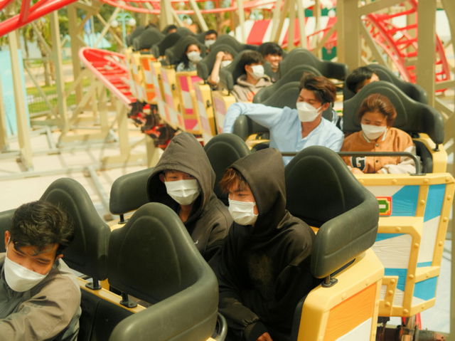 People riding roller coaster