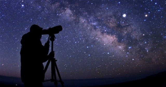 Pessoa observando céu estrelado com telescópio