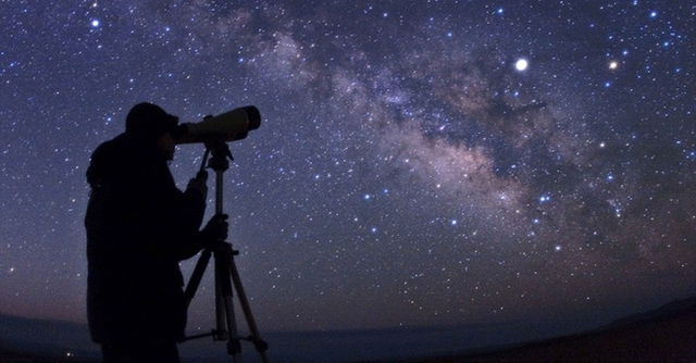 Pessoa observando céu estrelado com telescópio