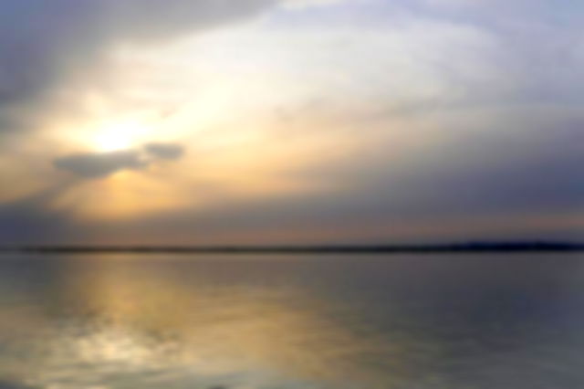 Sunset breaking through the cloudy sky over the ocean.