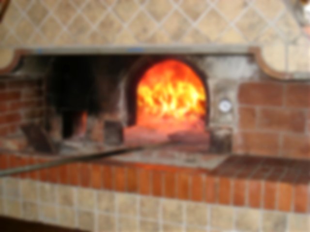 A fire in a large brick pizza oven
