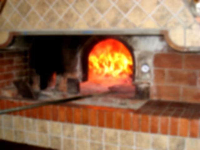 A fire in a large brick pizza oven