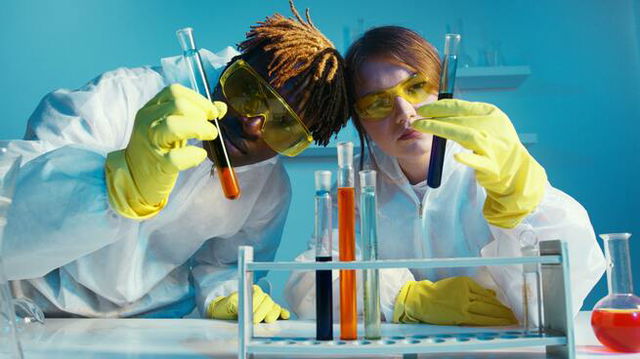 A man and a woman scientist holding two test tubes