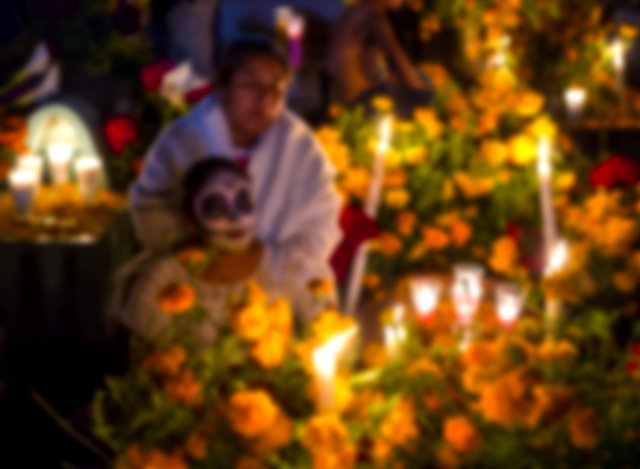 People visit the graves of their family members on the Day of the Dead