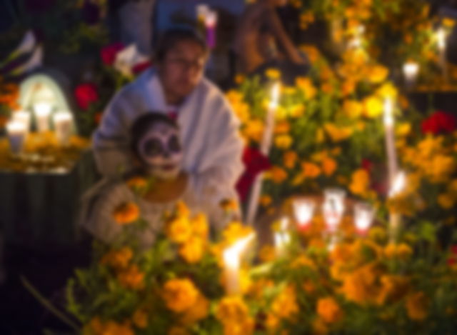 People visit the graves of their family members on the Day of the Dead