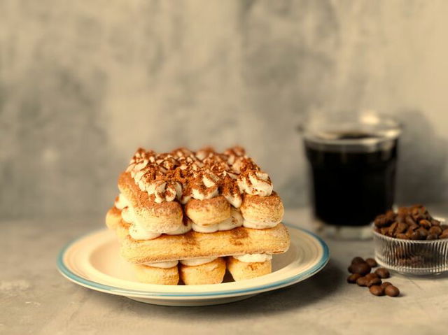 tiramisú en plato. granos de café y vaso de café