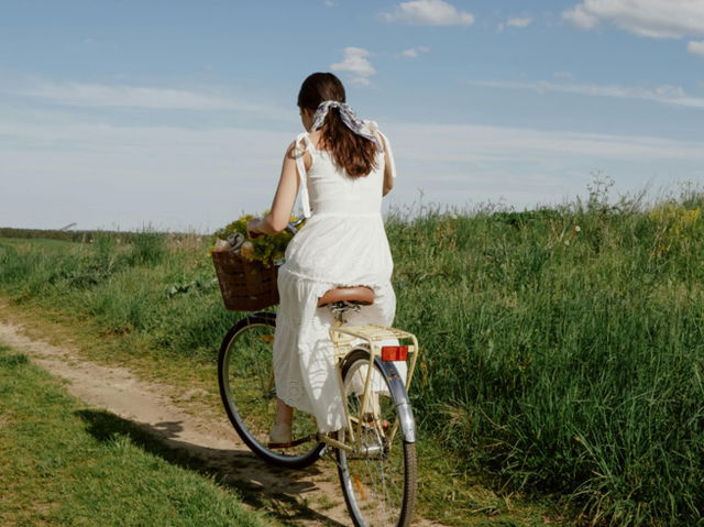 A woman cycling though the fields