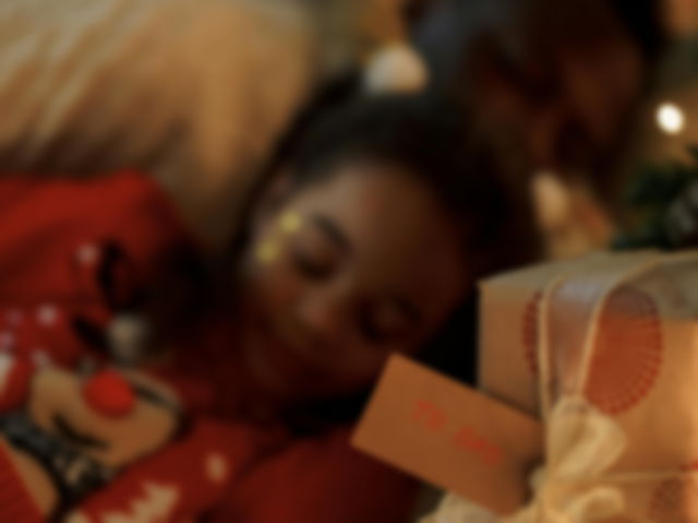 Father and daughter sleeping with a gift packed next to them