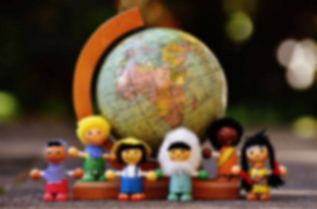Globo terráqueo junto a unos muñecos que representan diferentes nacionalidades
